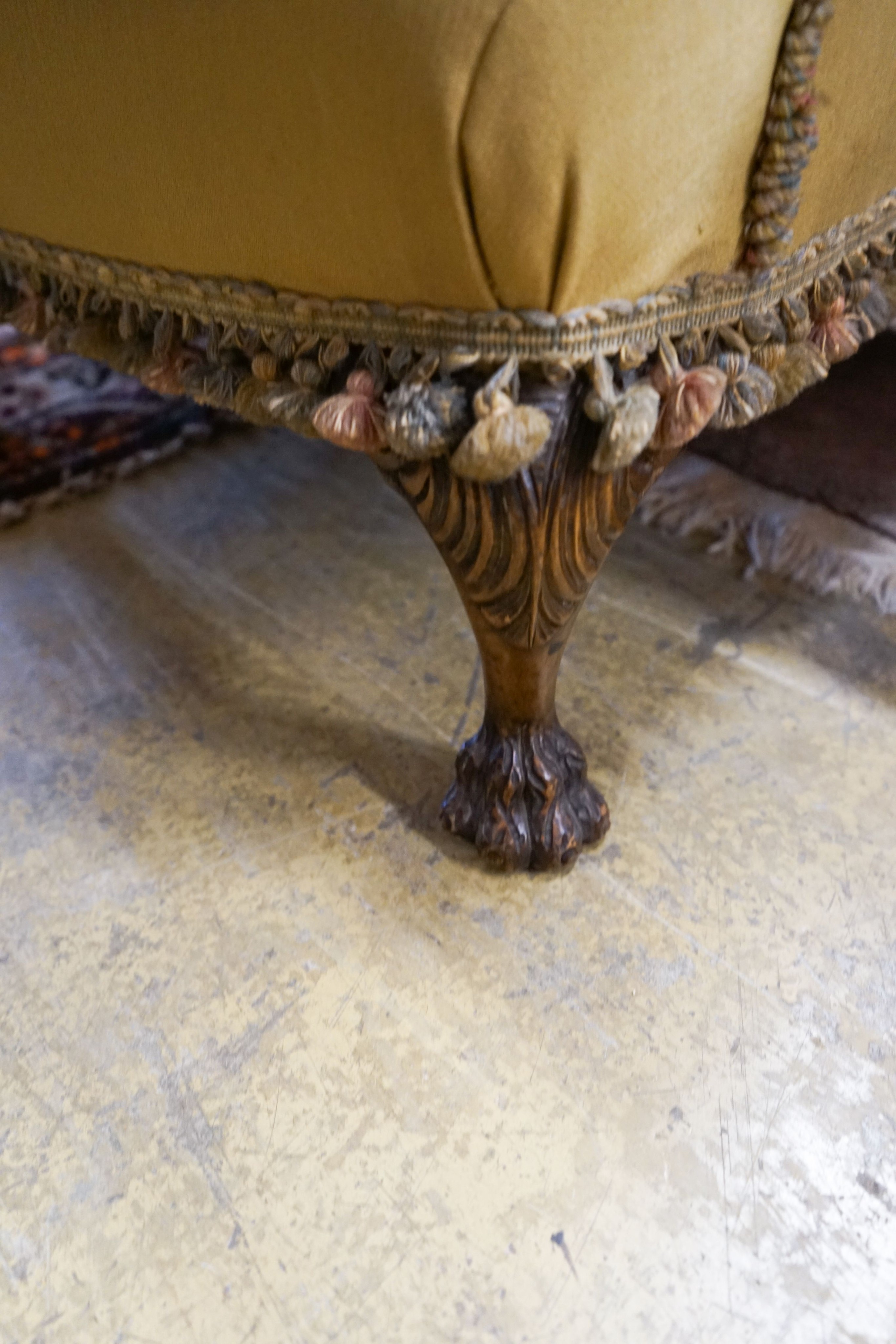 A wing frame armchair, upholstered in gold with embroidered flowers, on carved lion’s paw feet, width 80cm, depth 80cm, height 102cm